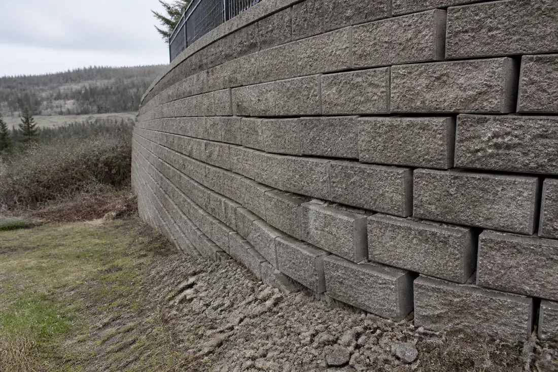 A segmental block retaining wall leaning outward with open joints
