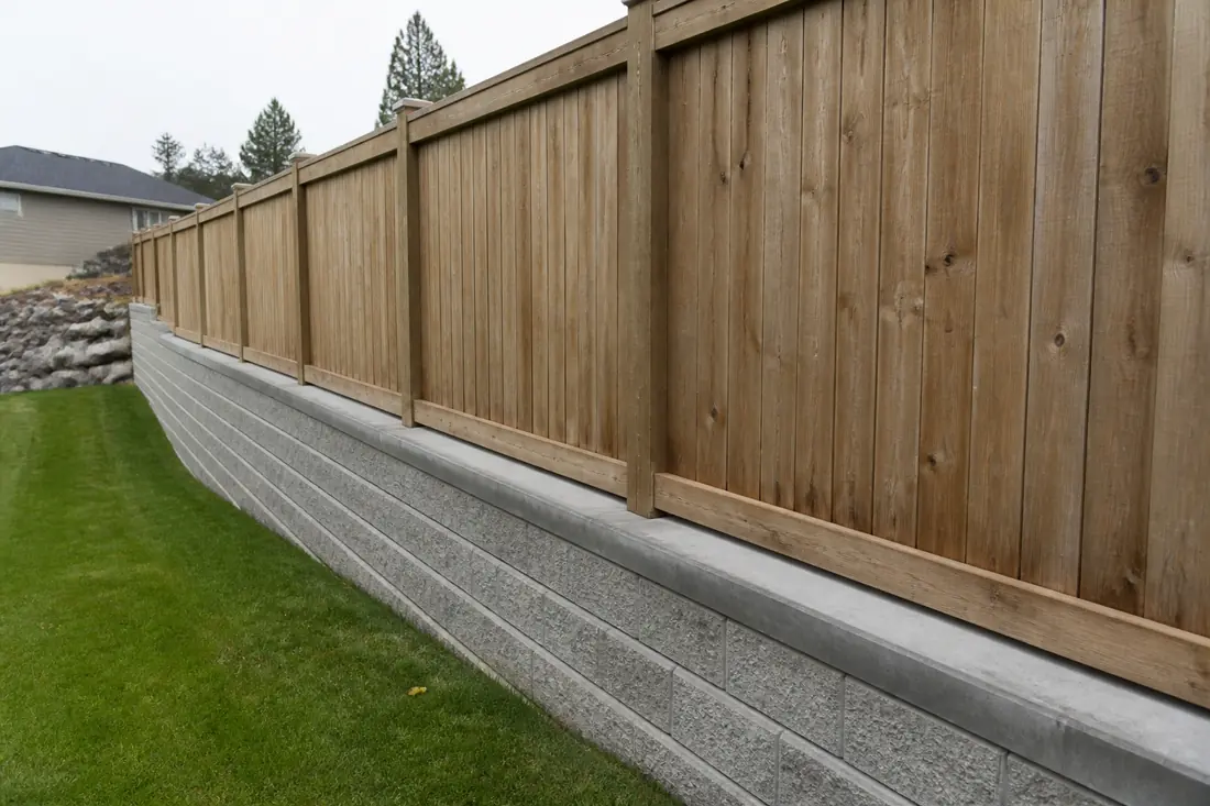 A fence built directly on top of a retaining wall